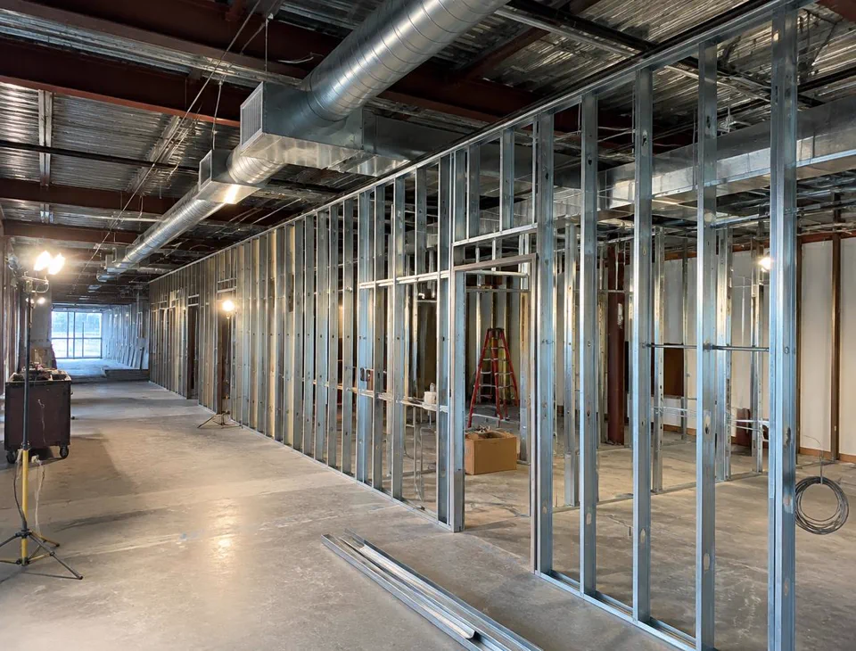 Commercial office space mid-renovation with metal stud drywall framing